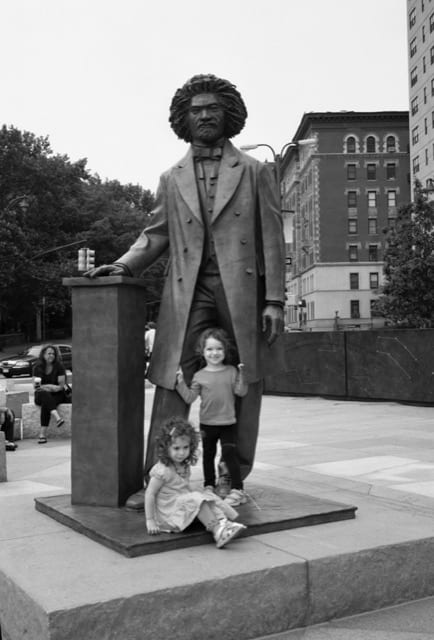 2 kids in front of Frederick Douglas statue